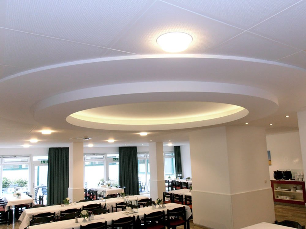 Individuelle Deckensysteme im Trockenbau mit modernem Design Runde abgehängte Deckenkonstruktion im Trockenbau mit integrierter Beleuchtung in einem Gastronomiebereich